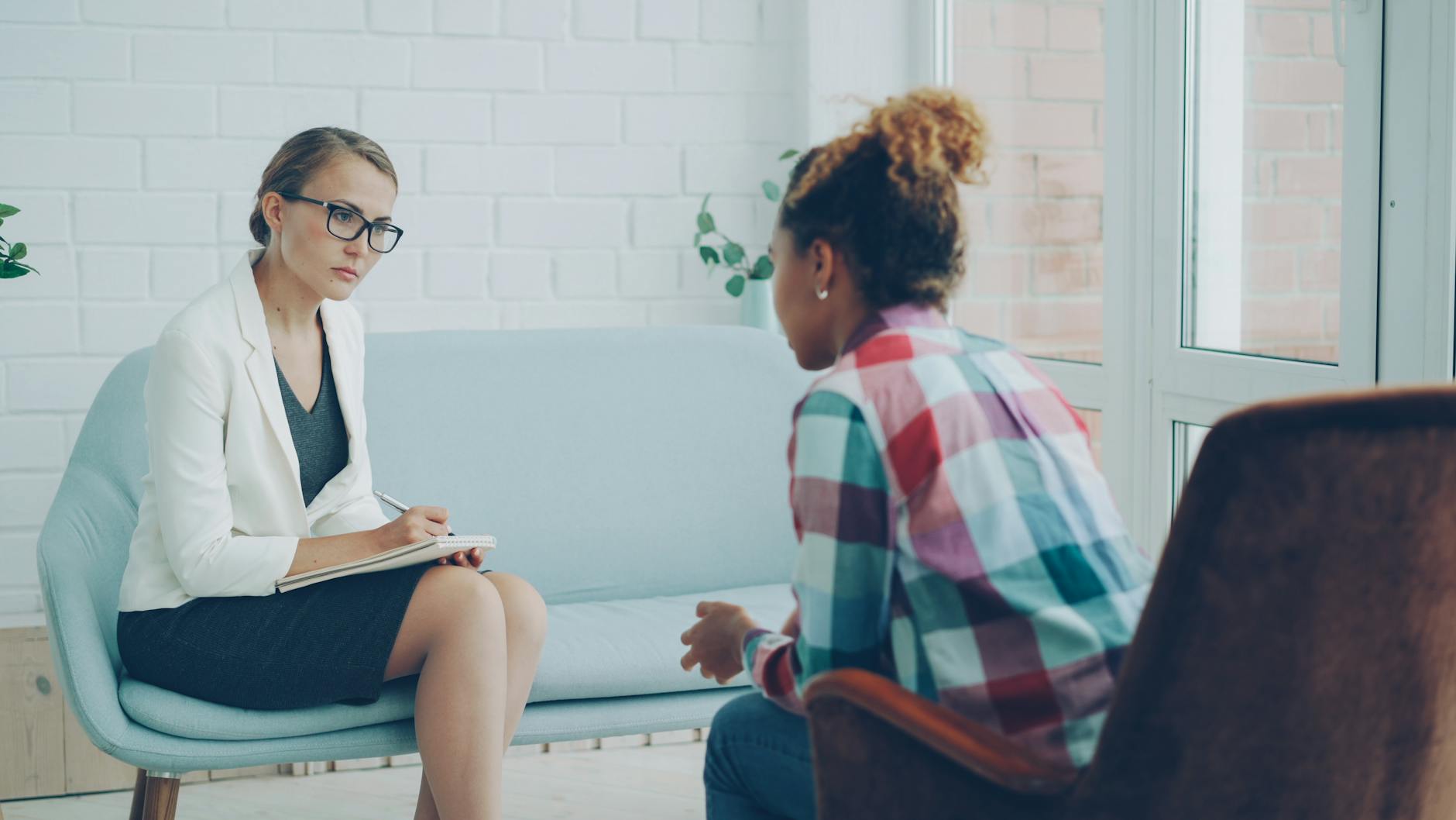 A therapist listening attentively during a private counseling session, representing the supportive professional relationships that help adults with ADHD thrive